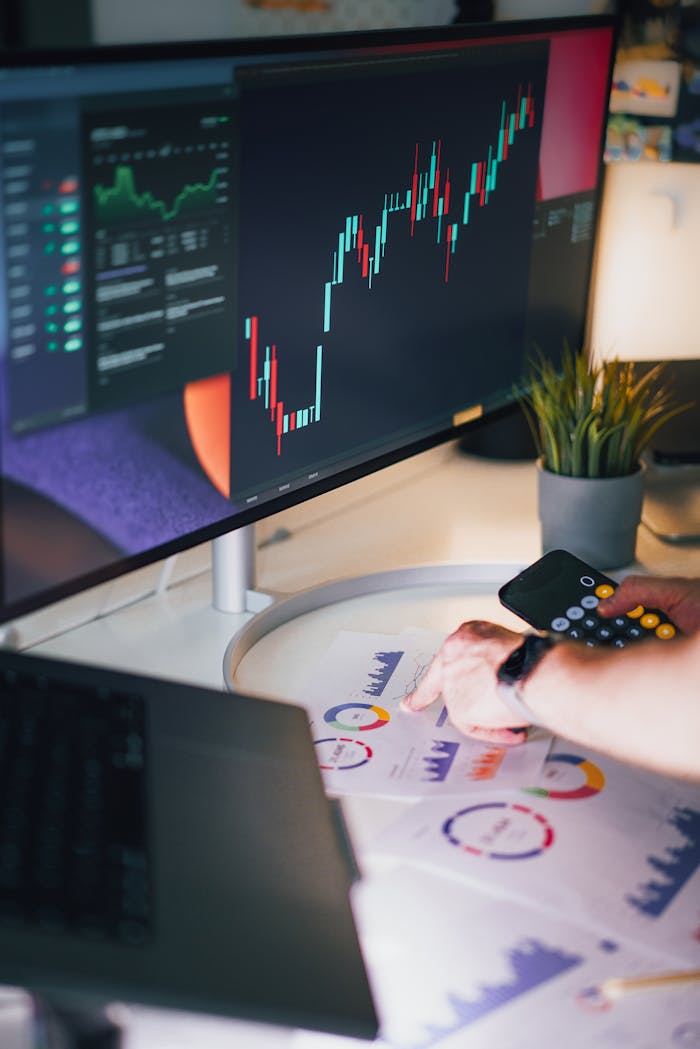 Modern workspace setup with financial charts and gadgets, ideal for business analysis.